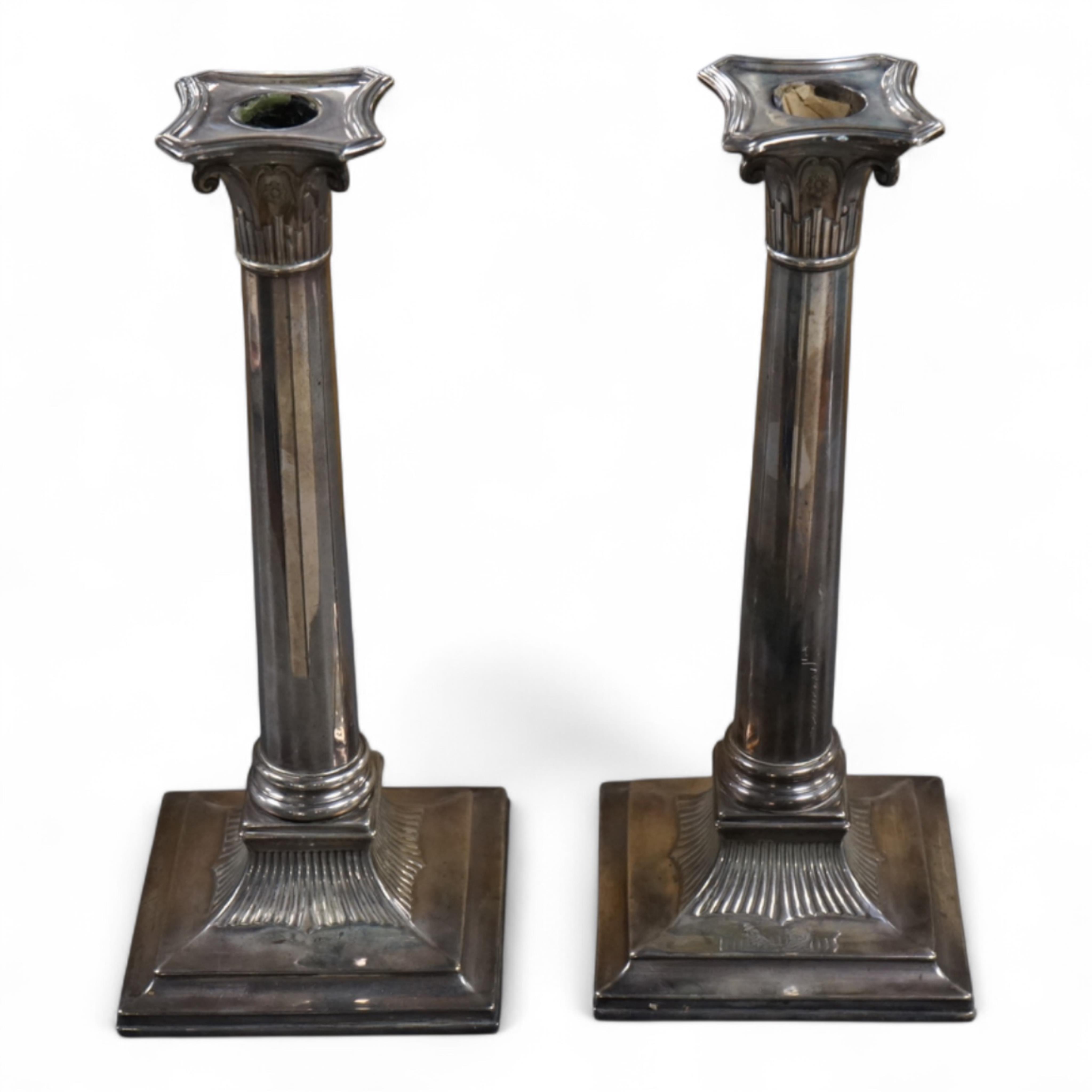 A pair of George III silver candlesticks by Luke Proctor & Co, with panelled stems(worn), on square bases with two engraved armorials, Sheffield, 1786, height 17.4cm, weighted (a.f.).